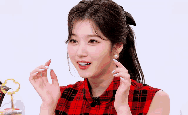 a close up of a woman wearing a plaid shirt and blue nails