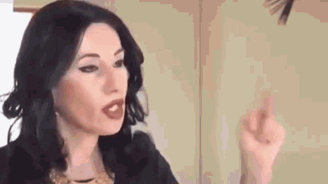 a woman is giving the middle finger to a man in a room .