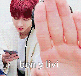 a man with red hair is holding a cell phone and says ben y livi on the bottom