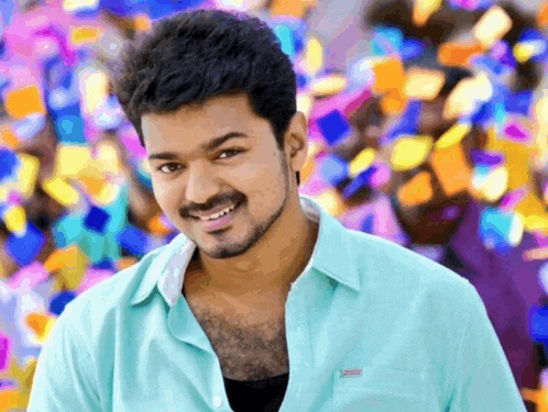 a man in a blue shirt is smiling with a colorful background