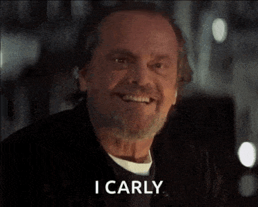 a man with a beard is smiling and says " i carly "