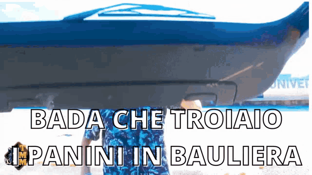 a person standing in front of a boat with the words " bada che troiaio panini in baulia "