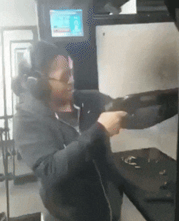 a woman is holding a gun in front of a screen that says ' i 'm sorry ' on it