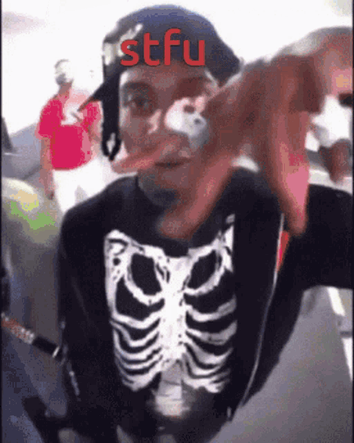 a man wearing a skeleton shirt with stfu written on it