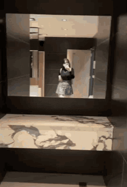 a woman is taking a selfie in a bathroom mirror