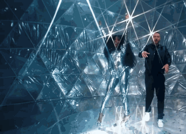 a man and a woman are dancing in front of a wall