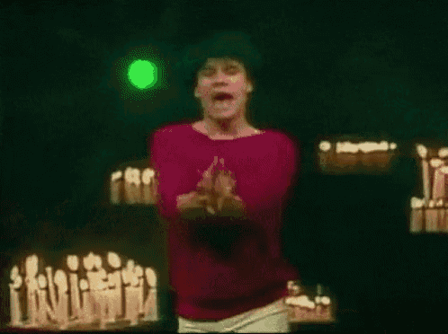 a man in a red shirt is standing in front of a green light