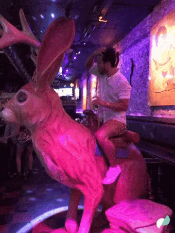 a man is riding on the back of a giant rabbit