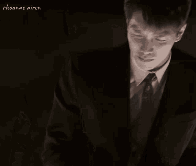 a man in a suit and tie is standing with his eyes closed .