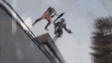 a couple of people are jumping off of a building .