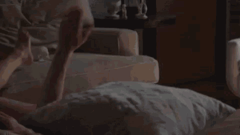 a woman is licking a man 's face while laying on the floor .