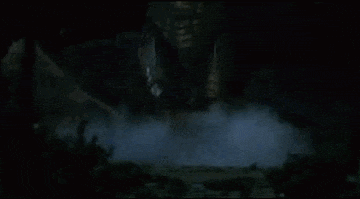 a giant monster is standing in the fog in the dark .