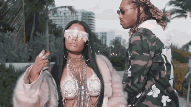 a man and a woman are standing next to each other and the woman is wearing blindfolds