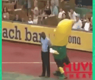 a yellow and green mascot is being held by a referee