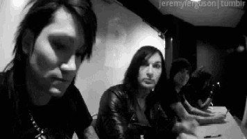 a group of people are sitting at a table in a dark room .