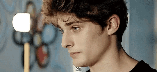 a close up of a young man 's face with the words " no " on the bottom right