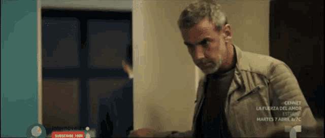 a man with gray hair and a beard is standing in a doorway .