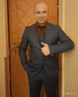 a man in a suit and tie is giving a thumbs up sign