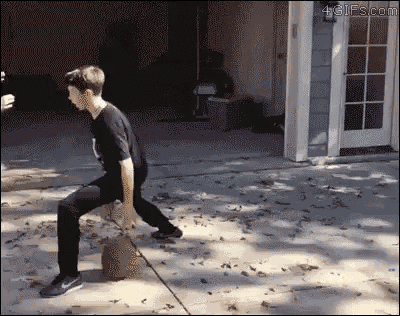 a boy is standing on a sidewalk in front of a garage with a gif from 4gifs.com on the bottom