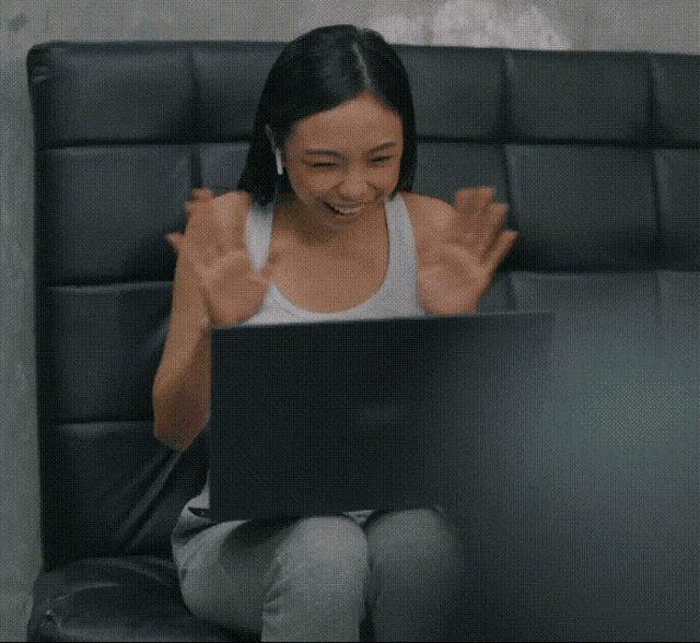 a woman is sitting on a couch using a laptop