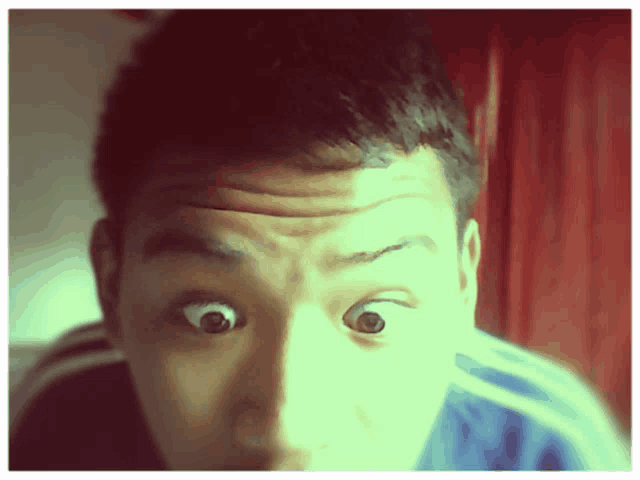 a close up of a person 's face with a surprised look on his face