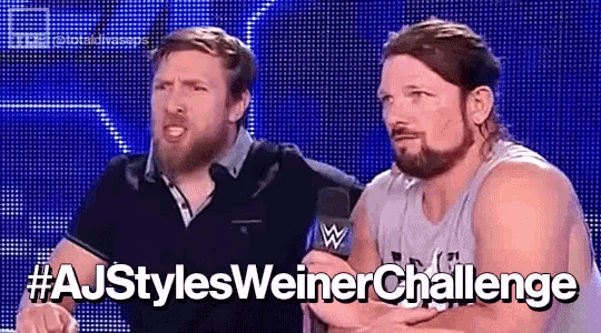 two men are standing next to each other in front of a microphone with the words aj styles weiner challenge written below them .