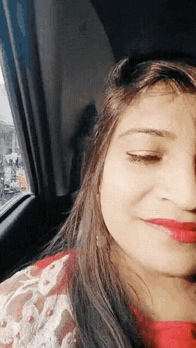 a close up of a woman 's face in a car looking out the window