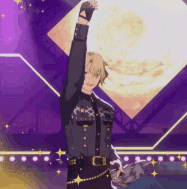 a man is standing on a stage with his arm up in the air