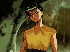 a man in a yellow shirt is standing in the rain with a tree in the background