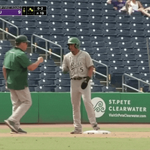a baseball player wearing a bulls jersey is standing on the base