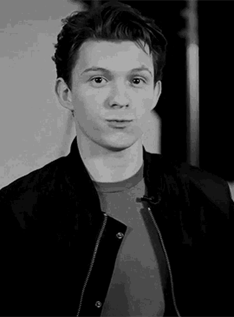 a black and white photo of a young man wearing a jacket
