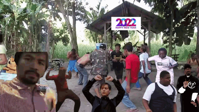 a group of people are dancing in front of a sign that says happy new year 2022