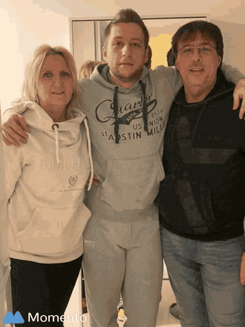 a man wearing a sweatshirt that says us union mills poses for a photo with his parents