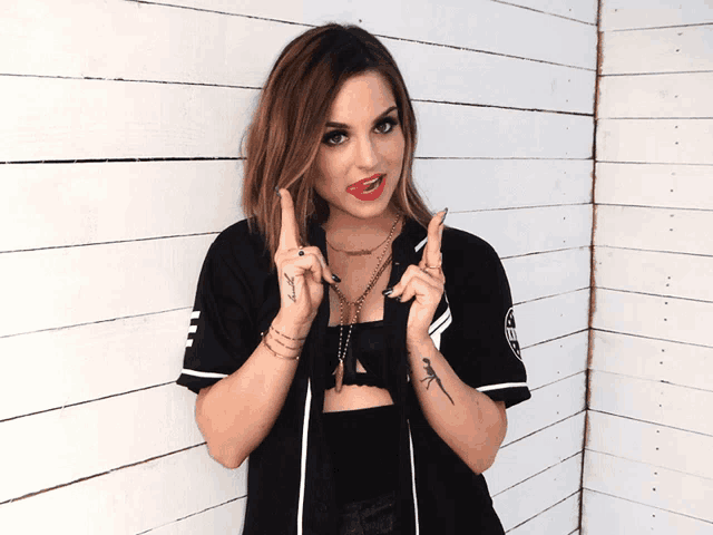 a woman with a tattoo on her arm is making a peace sign
