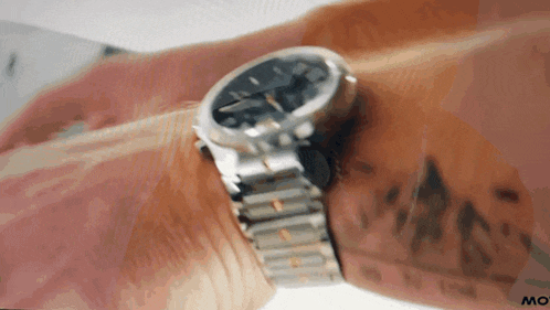 a close up of a person 's wrist with a watch and the word mo on the bottom