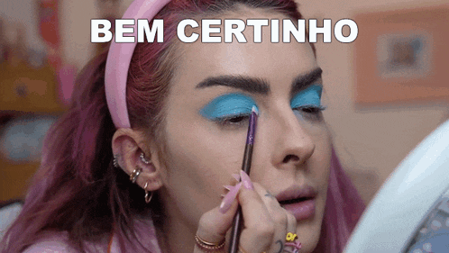 a woman with pink hair is applying makeup with the words bem certinho written above her