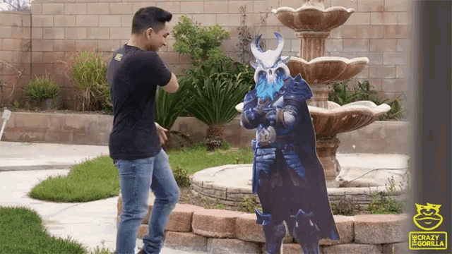 a man is standing next to a cardboard cutout of a samurai with horns