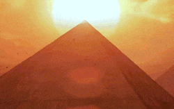 the sun is setting behind the pyramids in the desert