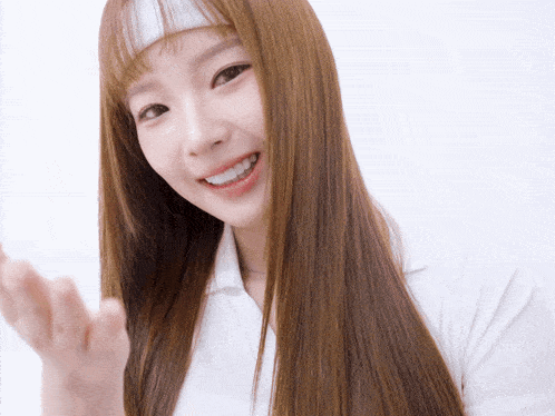 a woman with long hair wearing a white headband smiles