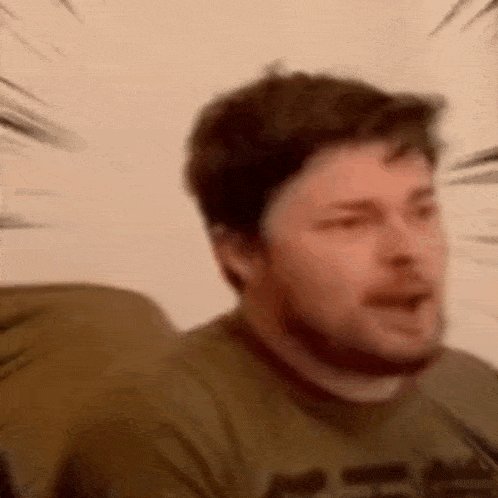 a man with a beard is making a funny face .