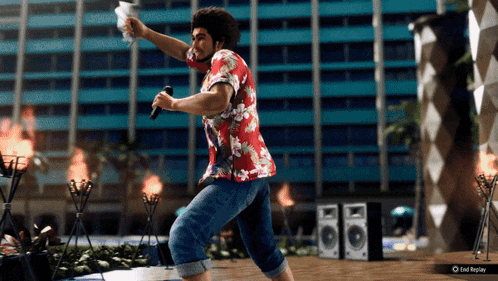 a man in a hawaiian shirt is singing into a microphone while holding a piece of paper