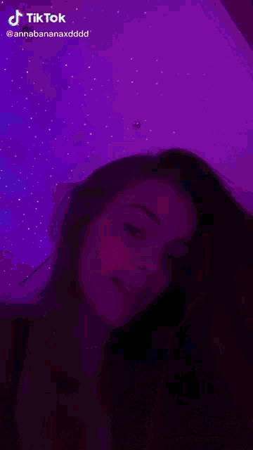 a woman is smiling in front of a purple background with tiktok written in the corner