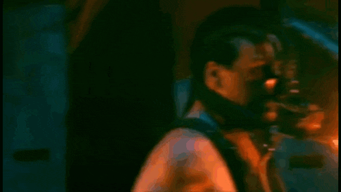a man is holding a torch in his hand in a dark room with a fire coming out of it .