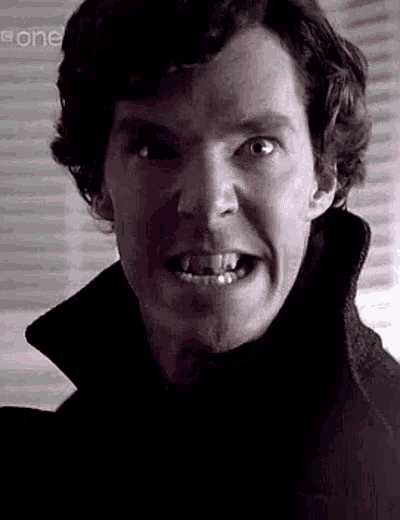 a close up of a man 's face with his mouth open and teeth showing .
