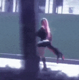 a woman with pink hair is holding a man in her arms