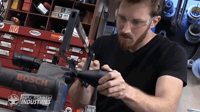 a man wearing safety glasses is working on a bosch machine