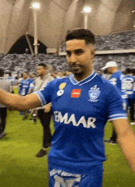 a man wearing a blue shirt that says emaar on it