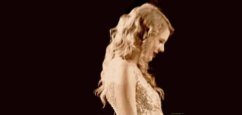 a woman in a white dress is dancing on a stage in front of a black background .