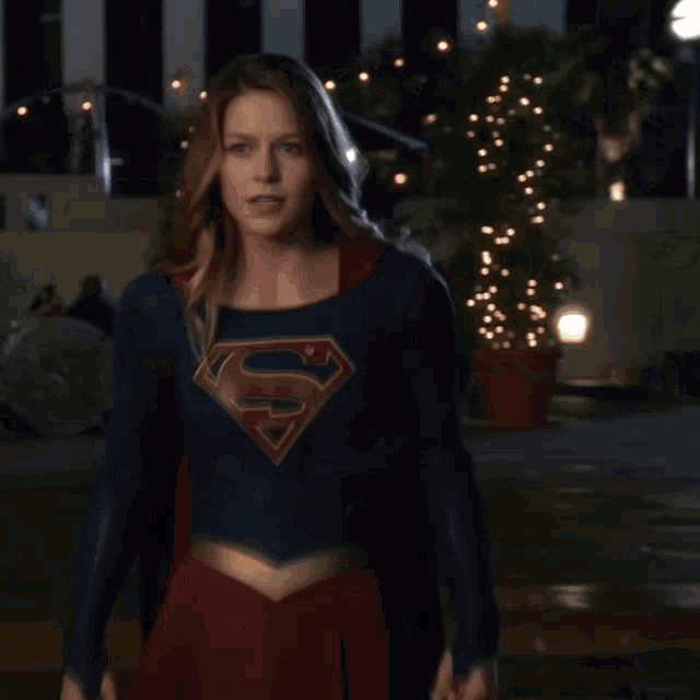 a woman is wearing a superman costume and looking at the camera
