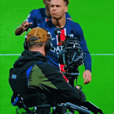 a soccer player wearing a qatar jersey stands in front of a cameraman